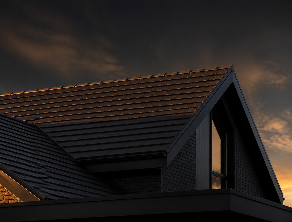 Modern home roofline with dark composite tile at dusk
